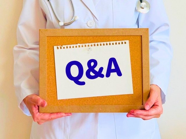 Q＆Aと書かれたボードを持つ医療従事者