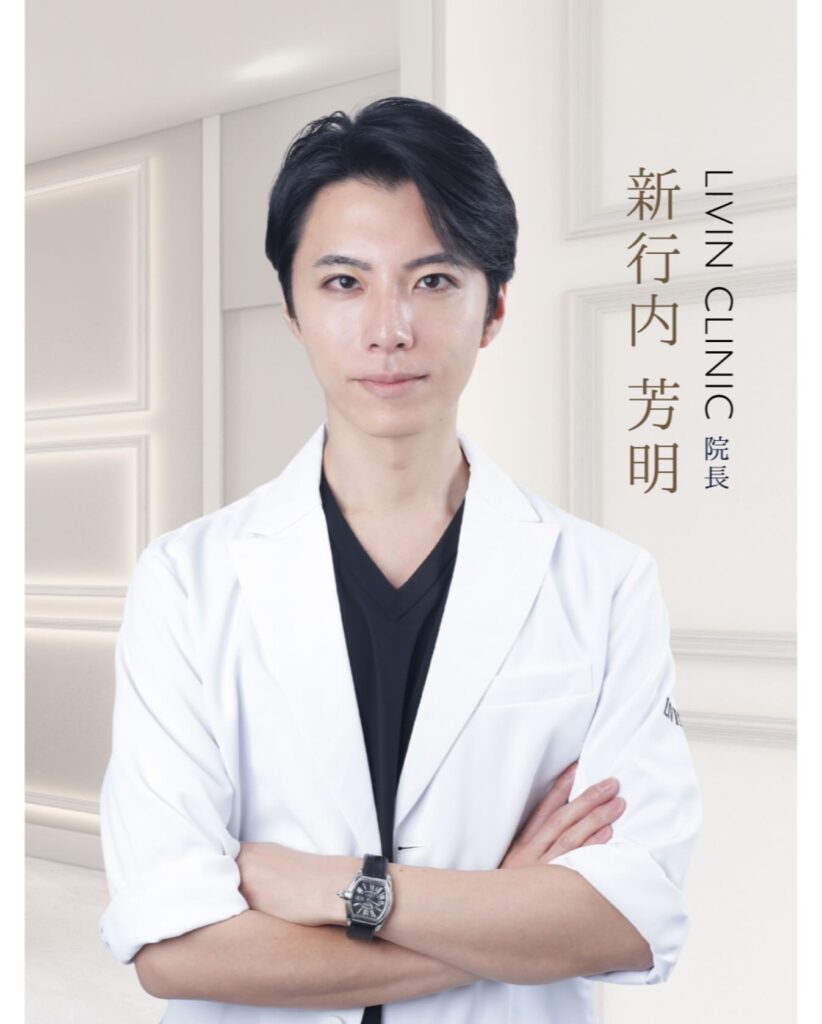 腕を組み微笑む新行内院長