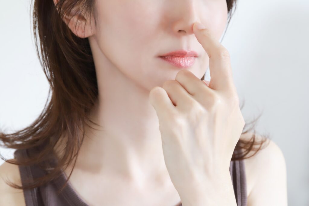 鼻先を押さえる女性