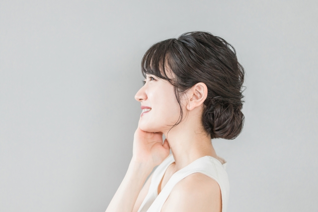頬に手を当てる笑顔の女性の横顔