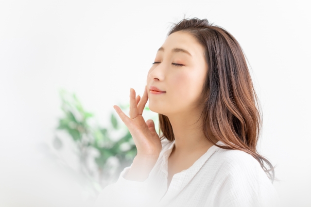 目をつむって肌の状態を確かめる女性