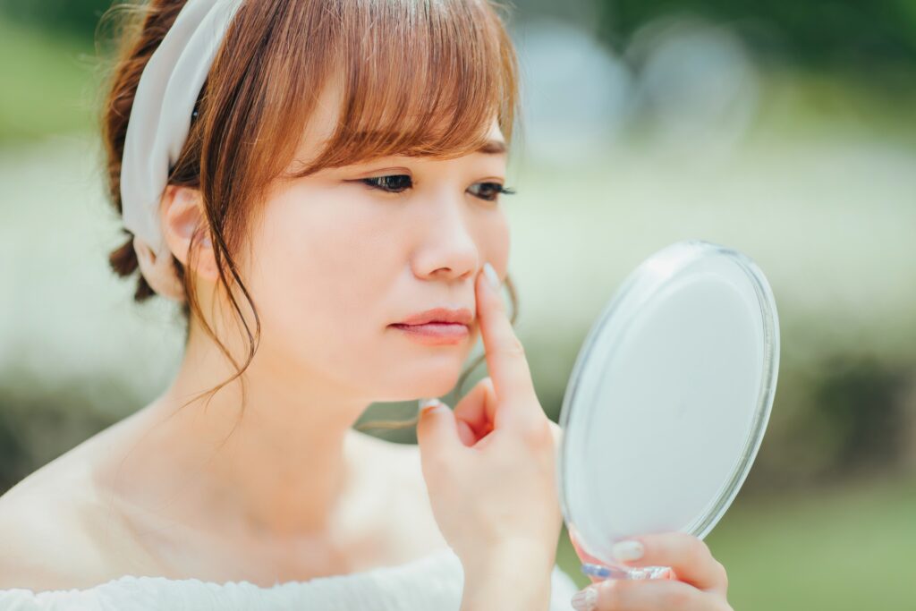 鼻の形を気にして鏡を見ている女性